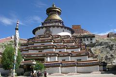 Tibet 06 07 Gyantse Kumbum Outside Commissioned by a Gyantse prince in 1270, the Kumbum chorten was built in the style of a 108-sided mandala by craftsman from the Kathmandu Valley, and houses many excellent unique frescoes of Newari influence, a painting style originating in Nepal's Kathmandu Valley. It rises in eight stages to over 52m and has lots of images (Kumbum means '100,000 images') and 70 chapels. It is topped in typical Nepalese Buddhist style with the all-seeing eyes, the spire, umbrella and the pinnacle. The first five floors are four-sided, while the upper floors are circular, forming a huge three-dimensional mandala.